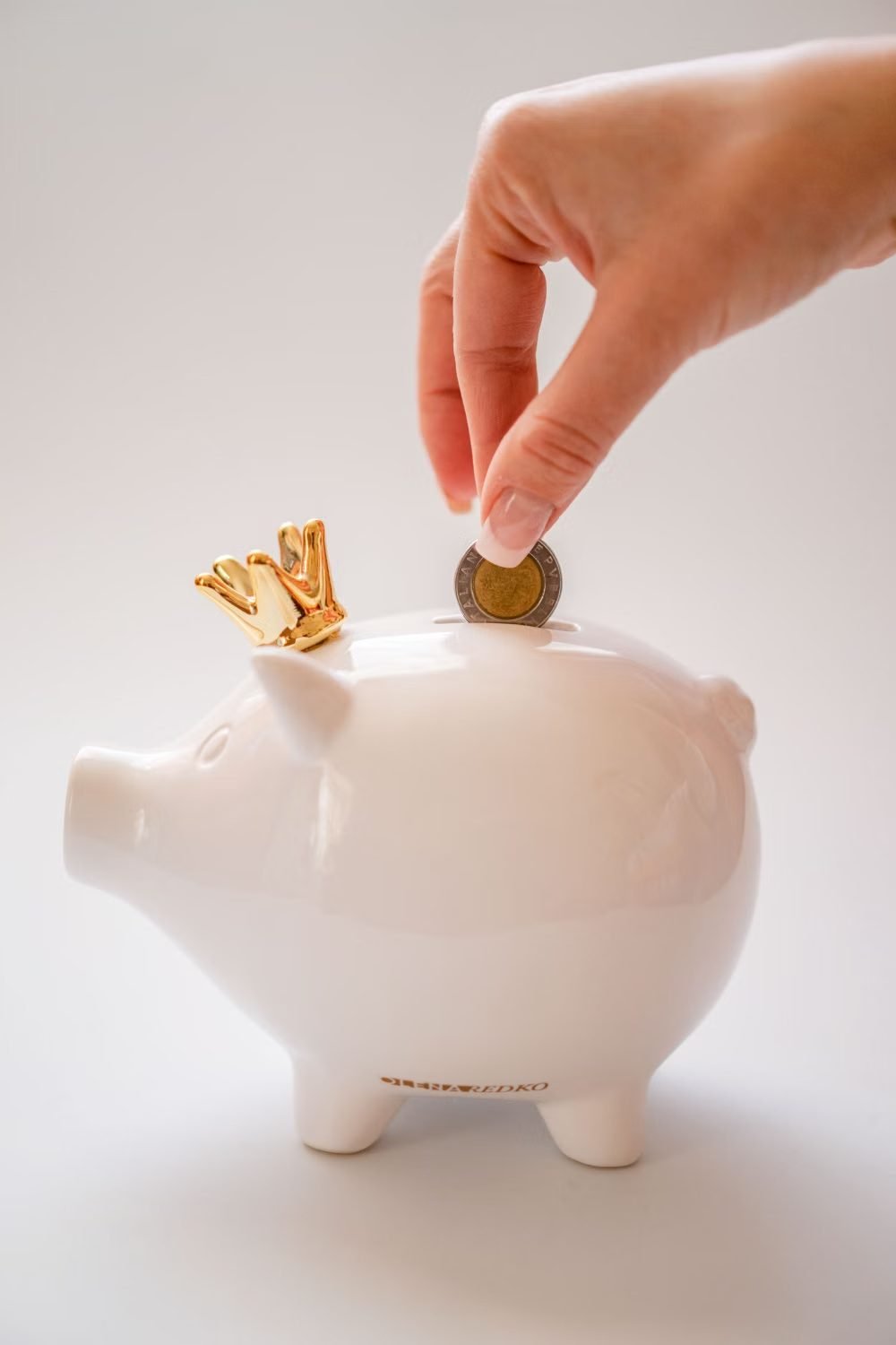 Moeda sendo depositada em um cofrinho